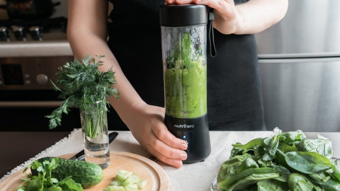 A person making a healthy green smoothie with fresh vegetables in a modern kitchen.