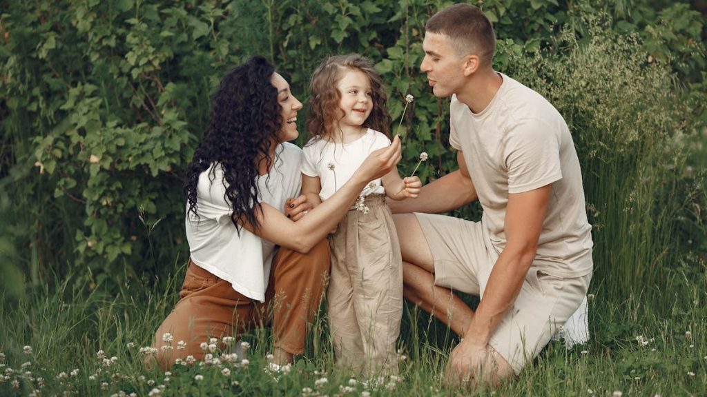 A joyful family enjoying time together in a lush green meadow, capturing love and bonding.